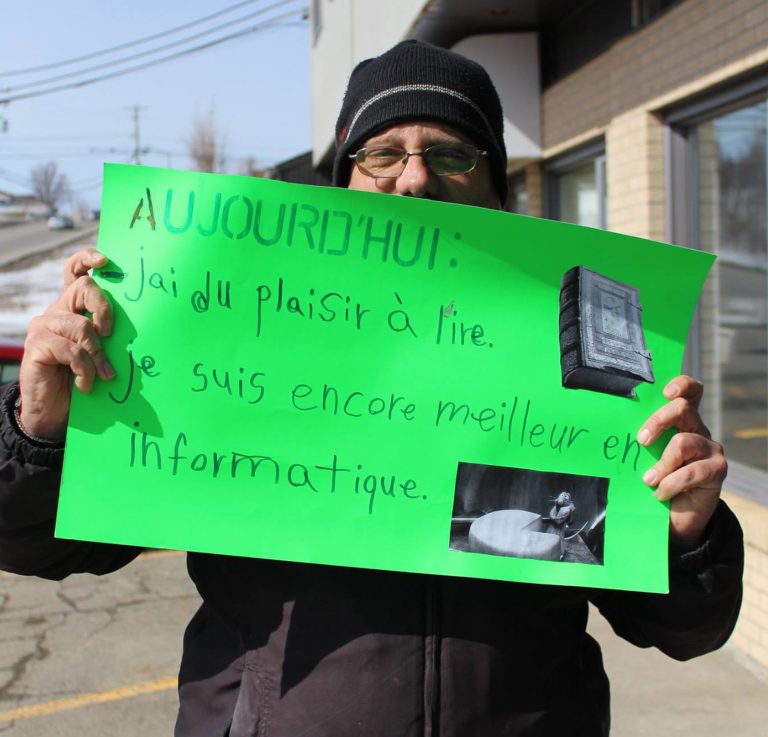 photo d'un client tenant une pancarte verte écrite à la main